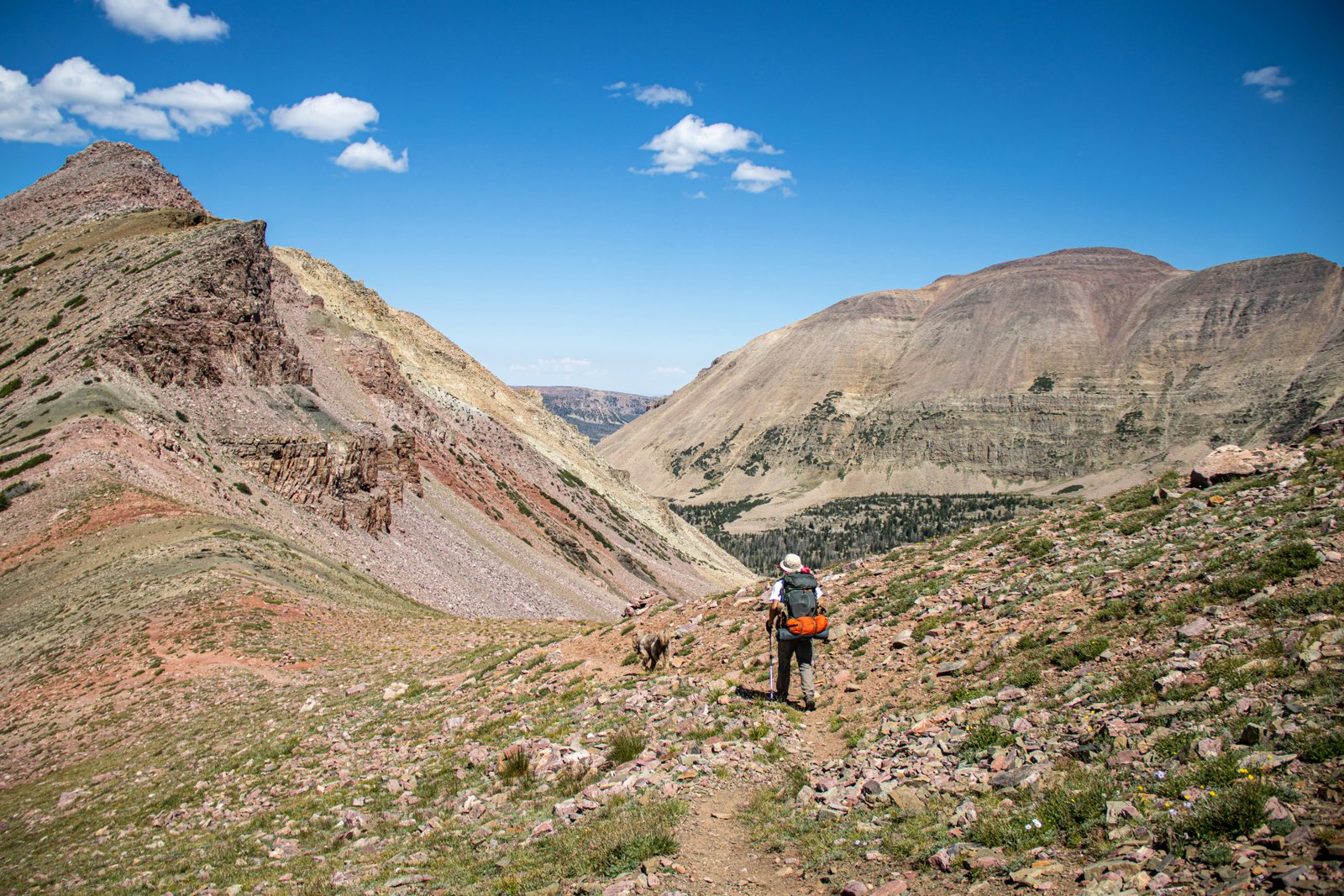 Hiker on a hot exposed mountain trail under blazing sun